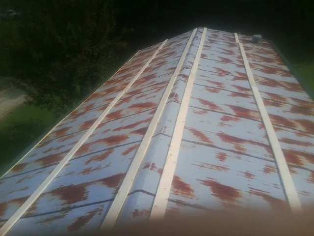 Rusted metal roof panels with new wood purlins before replacement — Storm Damage Roof Repair in Jerusalem by Roofing Brothers
